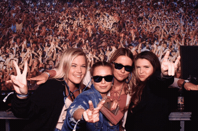 A Group Of Women Posing In Front Of A Crowd Of People GIF