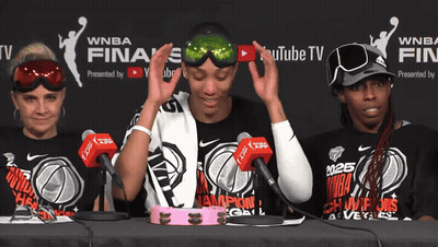A Group Of Women Sitting At A Table Wearing Shirts That Say Wnba GIF