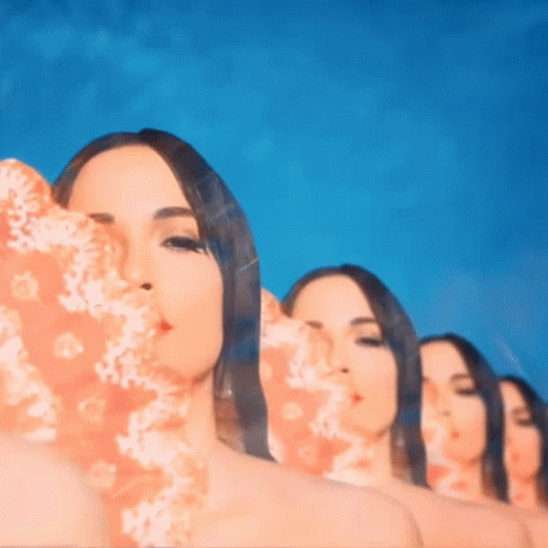 A Group Of Women Standing In A Row With Their Faces Covered GIF
