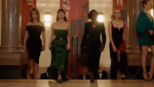 A Group Of Women Standing In Front Of A Red Banner With Chinese Characters GIF