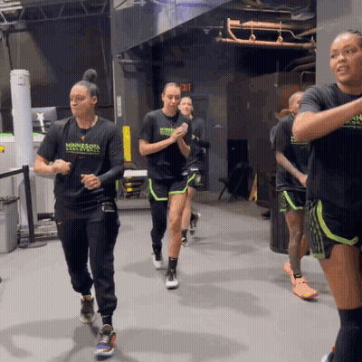 A Group Of Women Wearing Minnesota Basketball Shirts Are Running In A Gym GIF