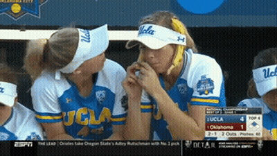 A Group Of Women Wearing Ucla Visors Are Eating Bananas GIF