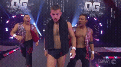 A Group Of Wrestlers Are On A Stage With The Letters Dg Behind Them GIF