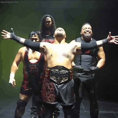 A Group Of Wrestlers Are Posing For A Photo And One Of Them Has A Belt That Says Heavyweight GIF