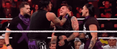 A Group Of Wrestlers Are Standing In A Ring And One Of Them Is Wearing A Shirt That Says ' X ' GIF