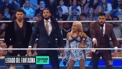 A Group Of Wrestlers Are Standing In A Ring With A Sign That Says Legado Del Fantasma On It GIF