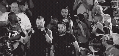 A Group Of Wrestlers Are Standing In Front Of A Crowd Of People . GIF