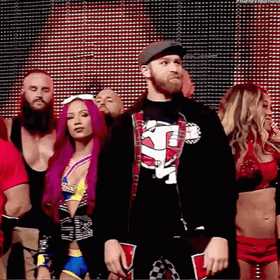 A Group Of Wrestlers Are Standing In Front Of A Large Screen And One Of Them Is Wearing A Shirt That Says Tna GIF
