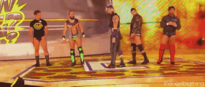 A Group Of Wrestlers Are Standing On A Wrestling Ring . GIF