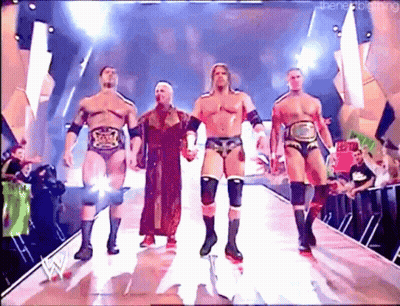A Group Of Wrestlers Are Walking Down A Ramp Holding Hands GIF