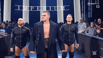 A Group Of Wrestlers Are Walking Out Of The Ring With The Word Imperium Behind Them GIF