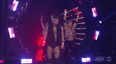A Group Of Wrestlers On A Stage With Aew Written On The Bottom Right GIF