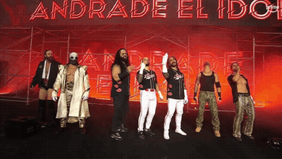 A Group Of Wrestlers Stand In Front Of A Sign That Says Andrade El Idol GIF