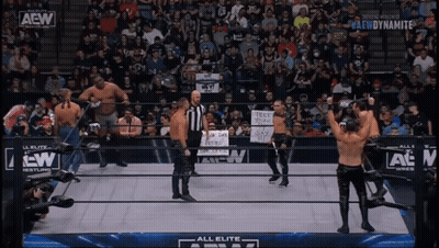 A Group Of Wrestlers Standing In A Ring With A Aew Logo GIF