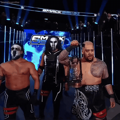 A Group Of Wrestlers Standing In Front Of A Sign That Says Smack Down GIF
