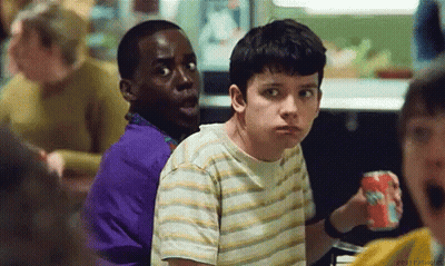 A Group Of Young Boys Are Sitting At A Table In A Restaurant . One Of The Boys Is Holding A Soda Can . GIF
