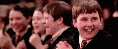 A Group Of Young Boys Are Sitting In A Row Clapping Their Hands . GIF