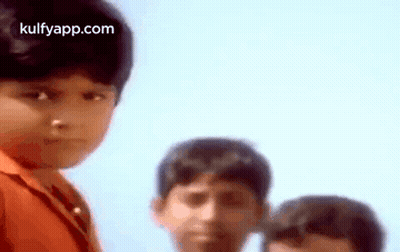 A Group Of Young Boys Are Standing Next To Each Other And One Of Them Is Looking At The Camera . GIF