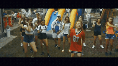 A Group Of Young Girls Are Dancing In Front Of A Coca Cola Cooler GIF