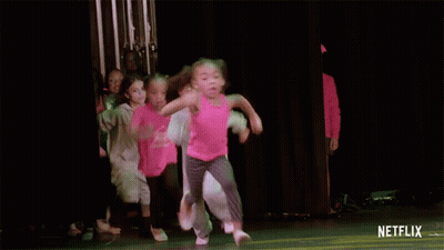 A Group Of Young Girls Are Dancing On A Stage With A Netflix Logo On The Bottom GIF