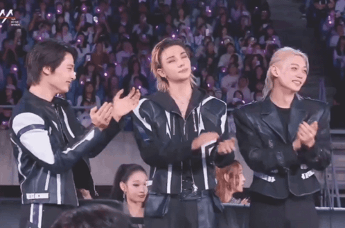 A Group Of Young Men Applauding In Front Of A Crowd With A Sign That Says Aa GIF