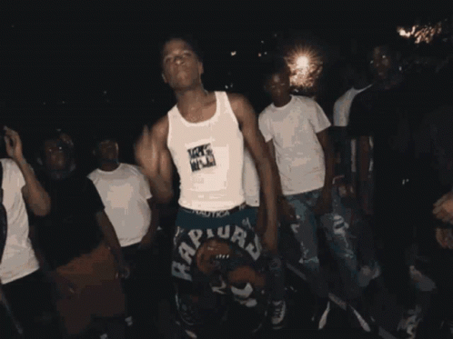 A Group Of Young Men Are Dancing And One Of Them Is Wearing A Raptors Shorts GIF