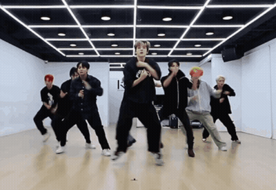 A Group Of Young Men Are Dancing In A Dance Studio With The Letter K On The Ceiling GIF
