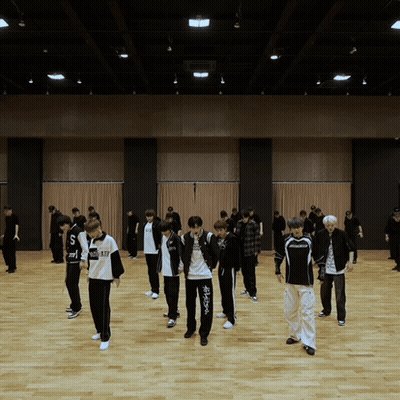 A Group Of Young Men Are Dancing In A Large Room And One Of Their Shirts Says ' Nc State ' On It GIF