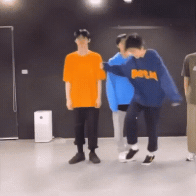 A Group Of Young Men Are Dancing In A Room . GIF