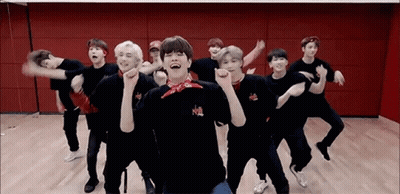 A Group Of Young Men Are Dancing In A Room . GIF