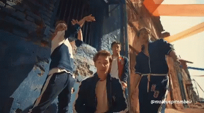 A Group Of Young Men Are Dancing In Front Of A Blue Wall And A Sign That Says @Maeuspitombeir GIF