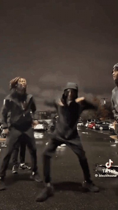 A Group Of Young Men Are Dancing In Front Of A Car In A Tik Tok Video . GIF
