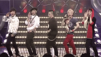 A Group Of Young Men Are Dancing On A Stage In Front Of A Crowd Of People . GIF