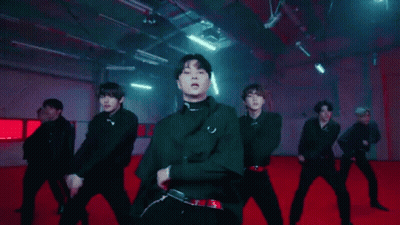 A Group Of Young Men Are Dancing Together On A Red Carpet In A Dark Room . GIF