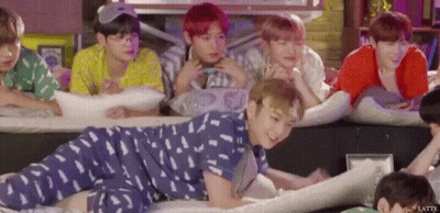 A Group Of Young Men Are Laying On Their Stomachs On The Floor . GIF