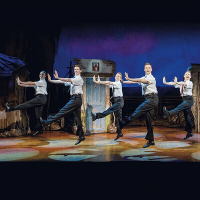 A Group Of Young Men Are Performing On A Stage GIF