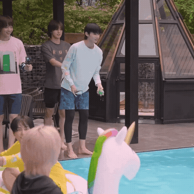 A Group Of Young Men Are Playing In A Swimming Pool With A Unicorn Float In The Middle GIF