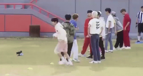 A Group Of Young Men Are Playing Soccer On A Field With A Bird . GIF