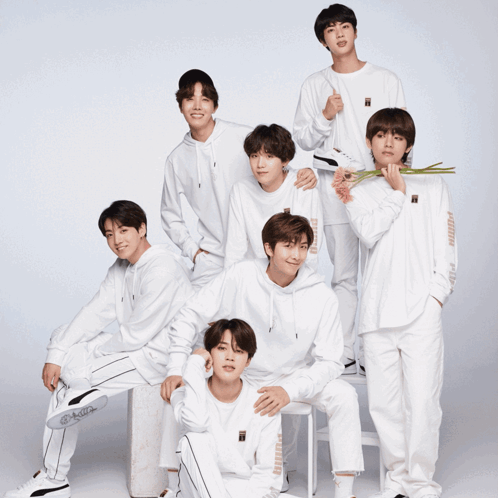 A Group Of Young Men Are Posing For A Picture And One Of Them Is Holding A Flower GIF