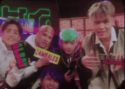 A Group Of Young Men Are Posing For A Picture And One Of Them Is Holding A Sign That Says Zambale . GIF