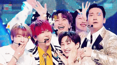 A Group Of Young Men Are Posing For A Picture On A Stage . GIF