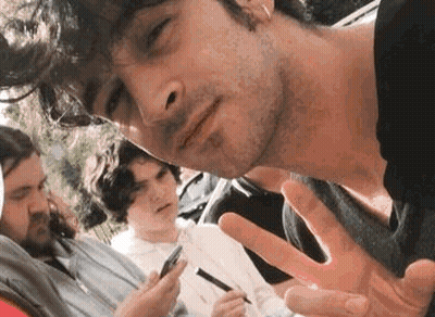 A Group Of Young Men Are Posing For A Picture While One Of Them Is Holding A Cell Phone In His Hand . GIF
