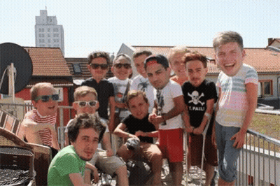 A Group Of Young Men Are Posing For A Picture With One Wearing A Shirt That Says Pauli GIF
