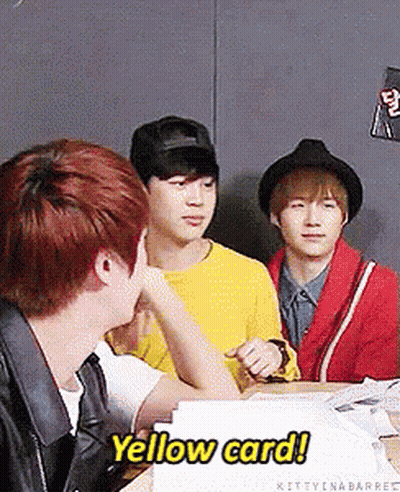 A Group Of Young Men Are Sitting At A Table And One Of Them Says Yellow Card GIF