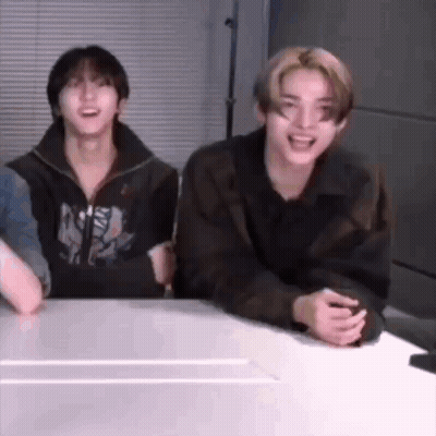 A Group Of Young Men Are Sitting At A Table Laughing And Smiling . GIF