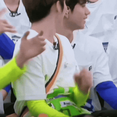 A Group Of Young Men Are Sitting In A Stadium And Applauding Each Other . GIF