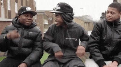 A Group Of Young Men Are Sitting Next To Each Other . GIF