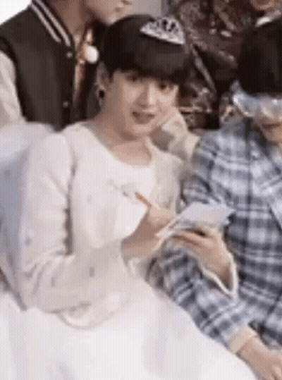 A Group Of Young Men Are Sitting Next To Each Other . GIF