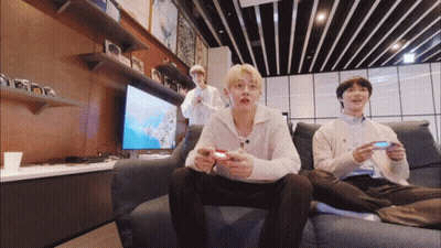 A Group Of Young Men Are Sitting On A Couch Playing Video Games GIF