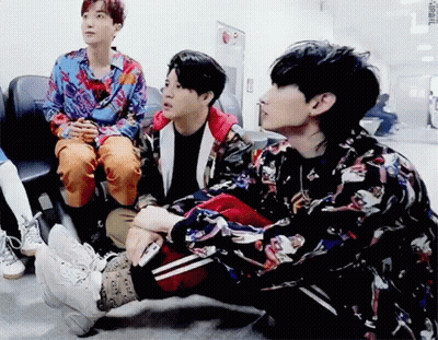 A Group Of Young Men Are Sitting On The Floor And Talking To Each Other . GIF